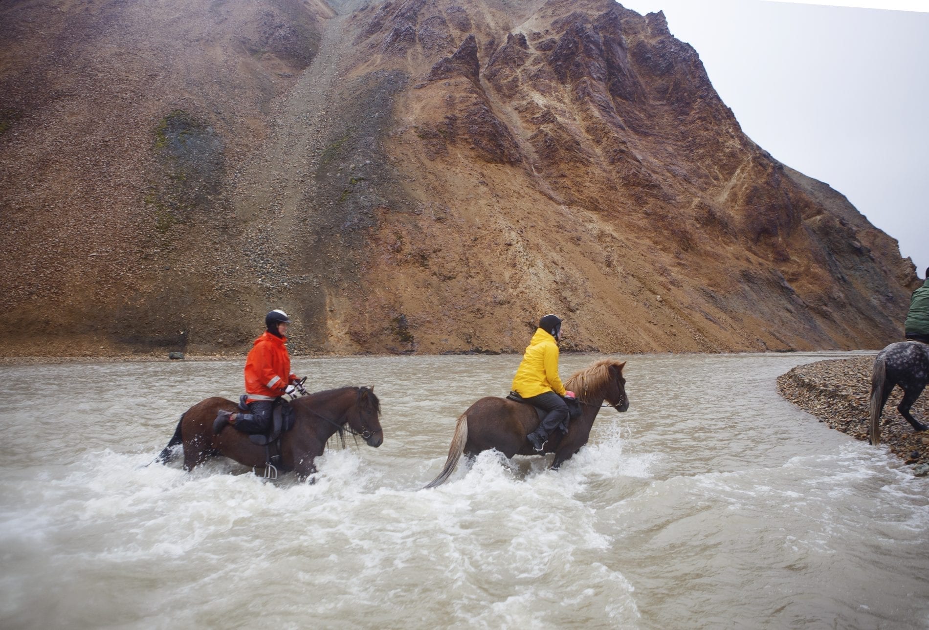 horse riding through a river full of water