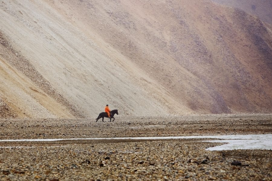 One man horseriding by the rhyolite monuntains of Landmannalaugar